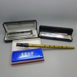 Three harmonicas including Swan Performance harmonica 24 and chromatic 12-48 harmonica and a tin