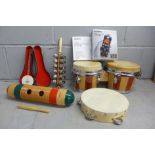 A set of bongos, a tambourine, a percussion piece, miniature model of a banjo, a Yamaha Pocketrak