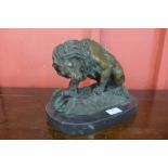 A bronze figure of a lion fighting a snake, on black marble plinth