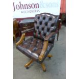 A mahogany and chestnut brown leather revolving chair