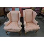 A pair of similar Queen Anne style walnut and fabric upholstered wingback armchairs
