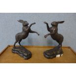 A pair of bronze boxing hares, on black marble socles