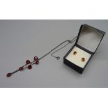 A pair of 9ct gold and garnet earrings and a silver and red stone necklace