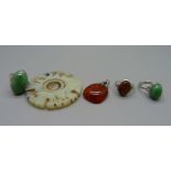 Two jade rings, a jade pendant, a silver mounted amber pendant and a silver amber ring