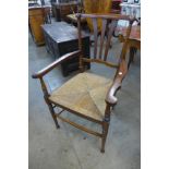 An Arts and Crafts mahogany rush seated elbow chair, manner of Liberty & Co.