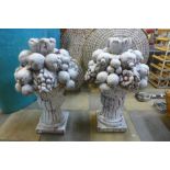 A pair of painted terracotta fruit bouquet garden ornaments