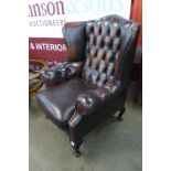 A mahogany and chestnut brown leather Chesterfield wingback armchair