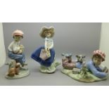 Three Lladro figures, two of boys with dogs and one with girl holding a basket of flowers