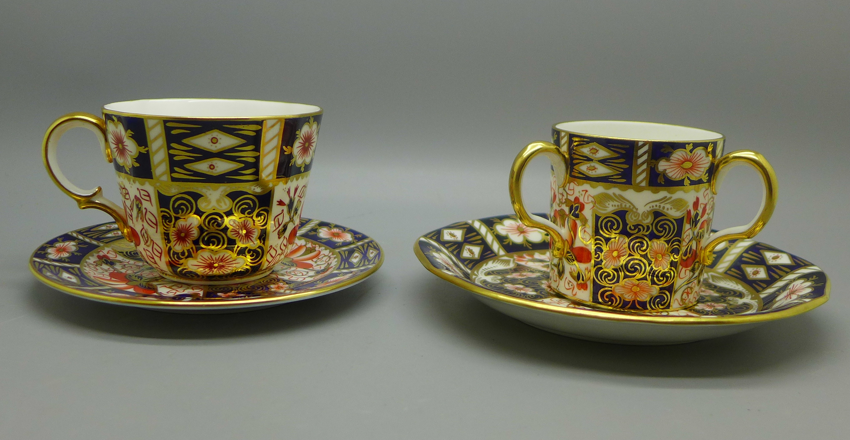 Two Royal Crown Derby Imari cups and saucers, one with three handles