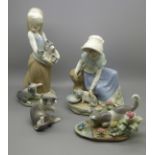 Four Lladro figures, two girls with kittens and two figures of cats (Some losses of petals)