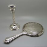 A silver candlestick and a hand mirror