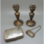 A silver cigarette case, a/f, 92g, a pair of silver candlesticks and a silver bottle label with