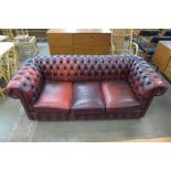 An oxblood red leather Chesterfield settee