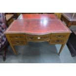 An Edward VII inlaid mahogany and red leather topped bow front writing table