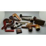 A collection of pipes, a Bakelite cased razor and a Bakelite cased cigarette holder