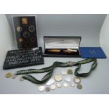 A collection of coins and a pen