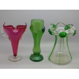 Three vases, circa 1900, cranberry posy vase, 17cm, an Art Nouveau iridescent green glass vase, 17cm