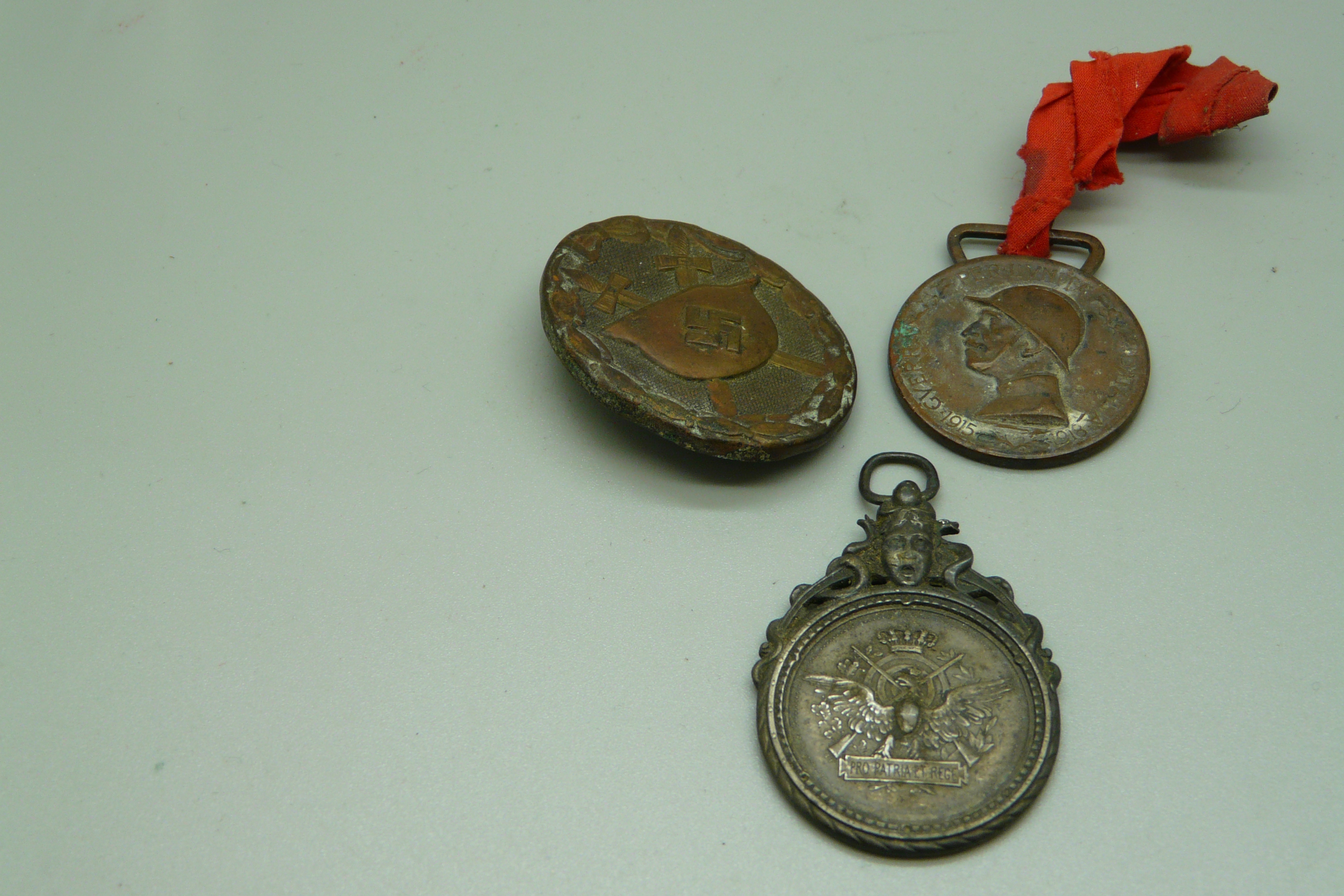 A German WWII badge and two medallions