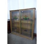 An Art Deco oak and stained glass sliding door school bookcase