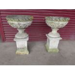 A pair of concrete garden urns on pedestal base's