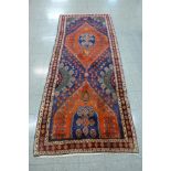 A hand knotted North West Iranian red ground runner rug, 314 x 132cms