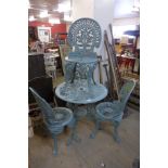 A cast alloy garden table and four chairs (one chair a/f)