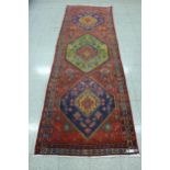 A Persian red ground runner rug, 317 x 108cms