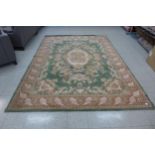 A large green ground rug, 331 x 240cms