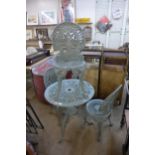 A cast alloy garden table and three chairs