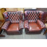 A pair of oxblood red leather Chesterfield wingback armchairs