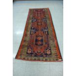 An eastern red ground rug, 320 x 123cms