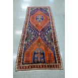A hand knotted North West Iranian red ground runner rug, 314 x 132cms