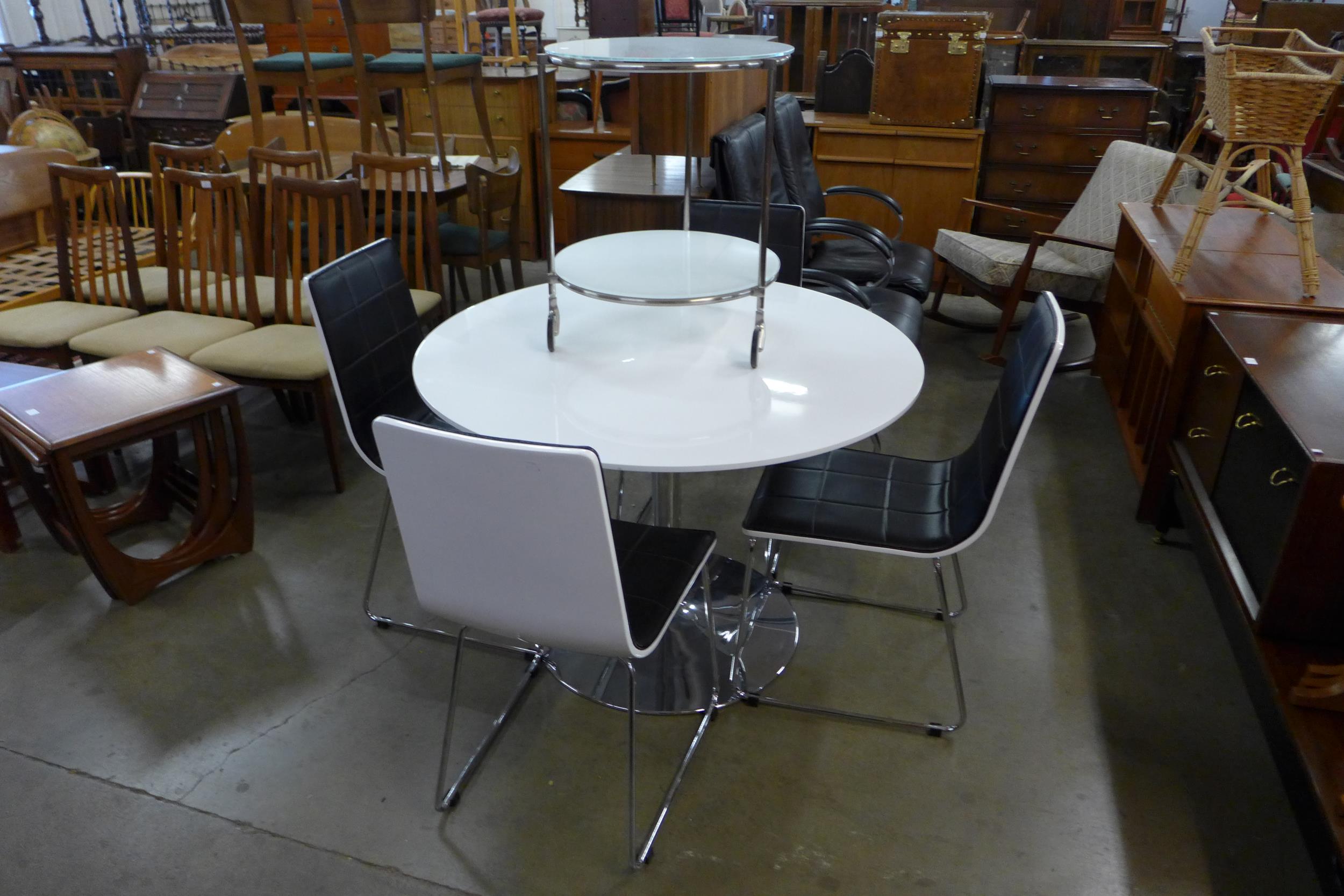 A chrome and white laminate circular table, four chairs and a trolley