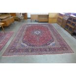 A large Persian hand knotted red ground Kashan rug, 409 x 206cms