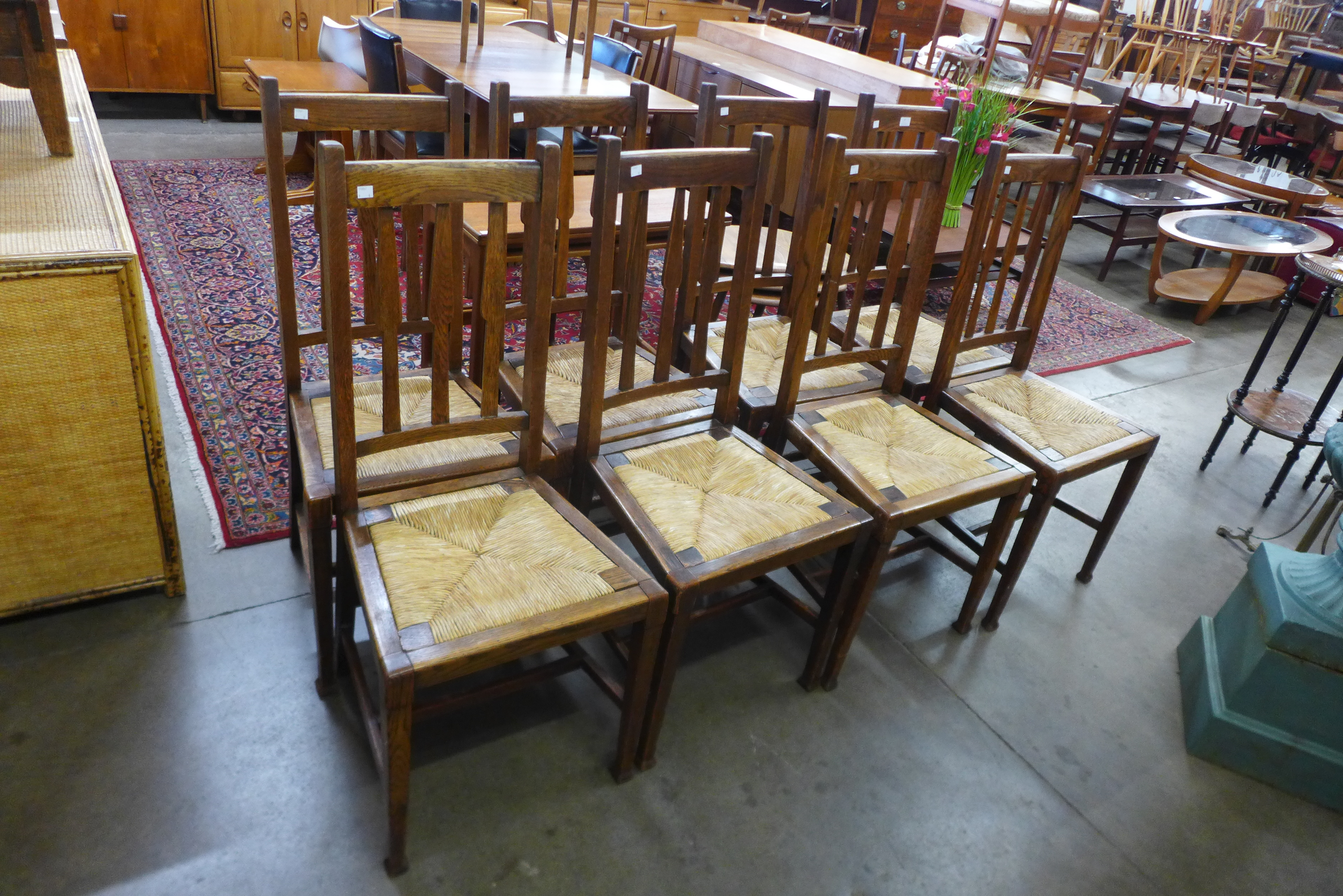 A set of eight Arts and Crafts oak rush seated chairs