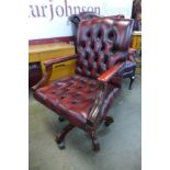 A mahogany and red leather revolving desk chair