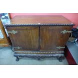 A Chippendale Revival carved mahogany press cupboard on a stand