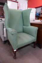 A Victorian mahogany and green fabric upholstered wingback armchair