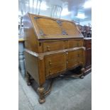 An early 20th Century carved oak cantilever action bureau