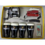 Two pairs of Guinness salt and pepper pots, a fishing reel and four pocket knives