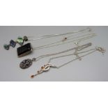 Four silver pendants and chains including amber set, onyx and marcasite