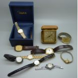 A collection of wristwatches and a travel clock