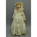 A miniature bisque head doll with blue glass sleep eyes and composition body, and original