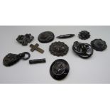 A carved jet pendant and a jet cross pendant, and eight brooches, one brooch a/f