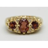 A 9ct gold ring set with garnets and white stones, 3.3g, M