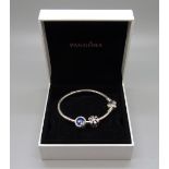 A Pandora silver bracelet, boxed with two charms