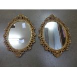 A pair of gilt metal framed oval wall mirrors