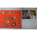 Eleven costume brooches and a tin of costume jewellery