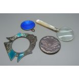 A magnifying glass with mother of pearl handle and silver mount, a silver backed handbag mirror, a