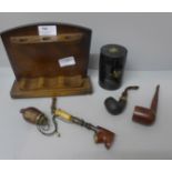 A wooden smokers stand with three pipes, and a John Players plastic tobacco container